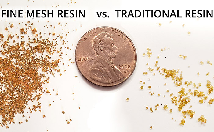 A macro comparison of standard water softener resin beads and smaller fine mesh resin beads.